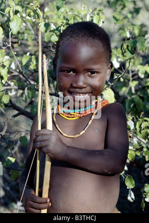 Tanzania, Arusha, Lake Eyasi. A Hadza boy carrying a bow and arrow. The Hadzabe are a thoUSAnd-strong community of hunter-gatherers who have lived in the Lake Eyasi basin for centuries. They are one of only four or five societies in the world that still earn a living primarily from wild resources. Stock Photo