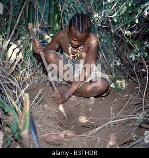 Tanzania, Arusha, Lake Eyasi. A Hadza woman digs for edible tubers with a digging stick.The Hadzabe are a thoUSAnd-strong community of hunter-gatherers who have lived in the Lake Eyasi basin for centuries. They are one of only four or five societies in the world that still earn a living primarily from wild resources. Stock Photo