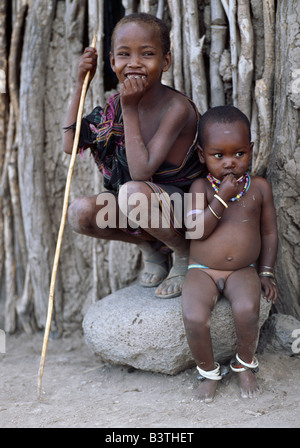 Tanzania, Arusha, Lake Eyasi. Two young Datoga boys. The youngest wears metal bells around his ankles to ensure that he does not wander far from home without his mother or another member of the family hearing him. The Datoga (known to their Maasai neighbours as the Mang'ati and to the Iraqw as Babaraig) live in northern Tanzania and are primarily pastoralists. Stock Photo