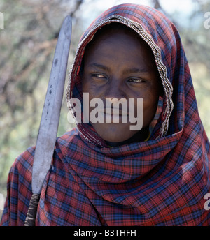 Tanzania, Arusha, Lake Eyasi. A Datoga young man, spear in hand, has decorated the edges of his check cotton wrap with old zips.The Datoga (known to their Maasai neighbours as the Mang'ati and to the Iraqw as Babaraig) live in northern Tanzania and are primarily pastoralists. Stock Photo