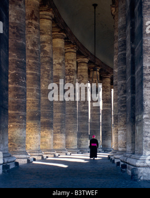 Europe, Italy, Rome, Vatican. Roman Catholic prelate walking between columns at St.Peter's Square. Stock Photo