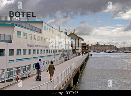 Amstel Botel a floating hotel in the Amsterdam Harbour with tourist walking down the ramp of the Oosterdok