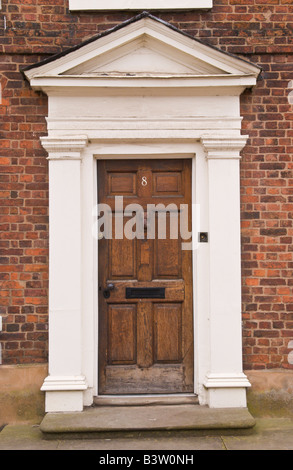 Brown wooden front door with white frame and pediment on townhouse in Ludlow Shropshire England UK