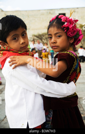 Children dancing in front of the Santo Domingo church dressed in Tehuana costumes during Easter celebrations in Oaxaca, Mexico Stock Photo
