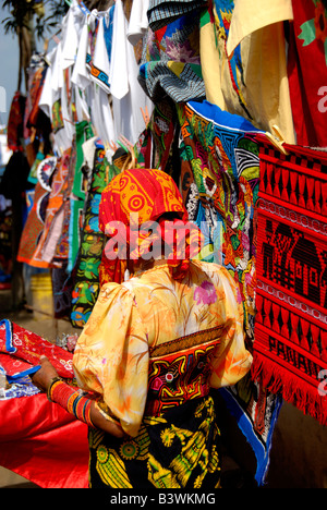 Central America, Panama, San Blas Islands. Kuna Indian in traditional attire in front of colorful hand stitched molas for sale. Stock Photo