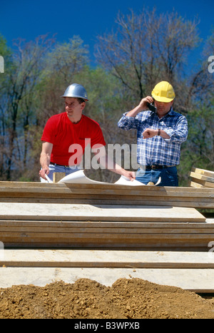 Two workers reviewing drawings on a construction site Stock Photo