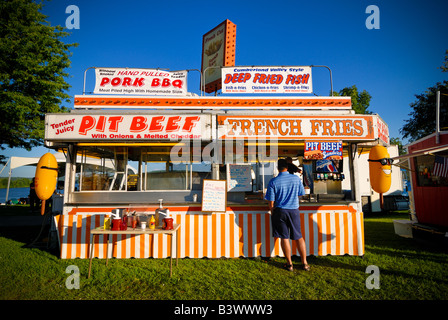 A man buys food at a refreshment stand at a carnival Stock Photo