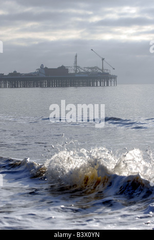 Waves break on Brighton beach, in front of the mist covered Pier, 2008 Stock Photo