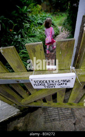 Toddlers at large - a home made sign hangs from the garden gate of a busy family home. Picture by Jim Holden. Stock Photo
