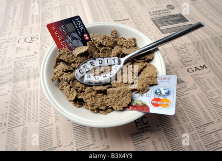 A SPOONFUL OF 'CREDIT CRUNCH' BREAKFAST CEREAL WITH COPY OF FINANCIAL PAPER AND CREDIT CARDS REPRESENTING FINANCIAL CRISIS,UK. Stock Photo