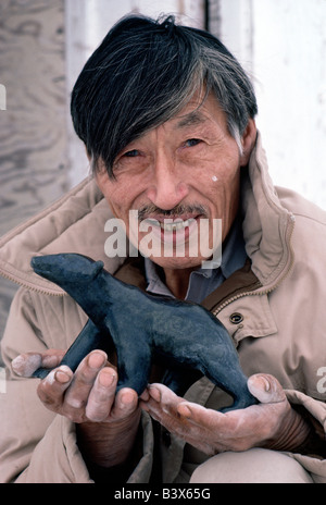 PORTRAIT OF HENRY WITH A CARVED SOAPSTONE POLAR BEAR, FAMOUS INUIT ARTIST, IQALUIT, BAFFIN ISLAND, NUNAVUT, NWT, CANADA Stock Photo
