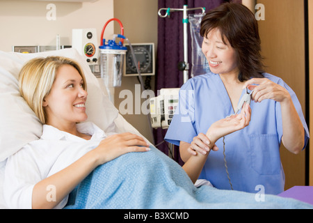 Doctor Taking Pregnant Woman’s Pulse Stock Photo