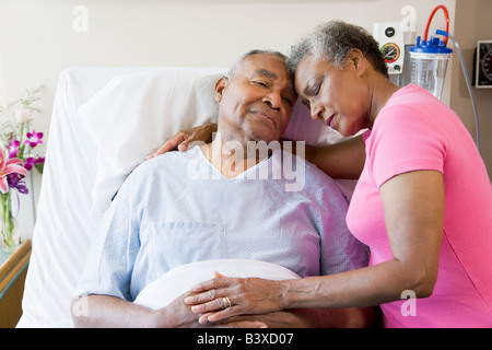 Senior Couple Embracing In Hospital Stock Photo