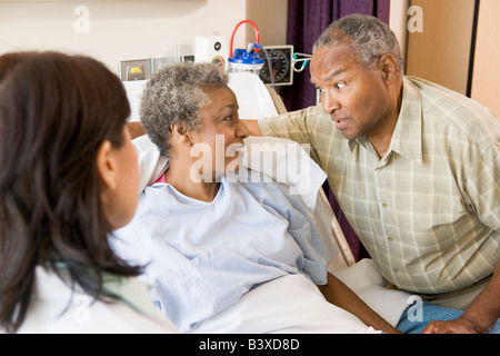 Doctor Explaining, Senior Couple Looking At Each Other Stock Photo
