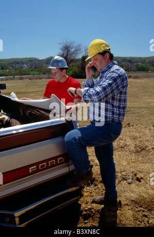 Two workers reviewing drawings on a construction site Stock Photo