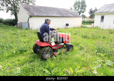 Man mowing a lawn on ride-on mower Stock Photo
