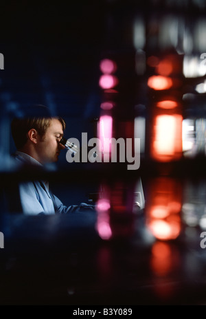 Technician checking water samples through a microscope in the quality control laboratory of a water treatment plant. Stock Photo