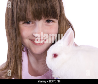 Young brunette girl with white pet bunny rabbit isolated on white background Stock Photo