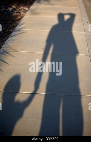 Shadow of young boy and Father walking on sidewalk Stock Photo