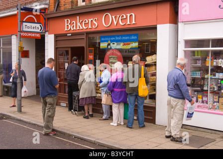 People queing to buy bread at the Bakers Oven bakery in Beccles Suffolk Uk Stock Photo