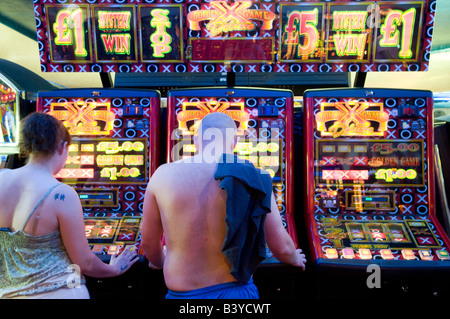 People playing on fruit machines in amusement arcade, UK Stock Photo