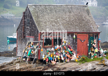 USA, Maine, Harpswell. Lobster buoys hang on fish shack on Bailey Island. Stock Photo