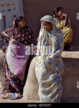 Sudan, Sahara Desert, Qubbat Selim. Three women relax outside a house at Qubbat Selim. This village, situated close to the River Nile in Northern Sudan, still retains much of its traditional architecture, plasterwork and decoration. Stock Photo