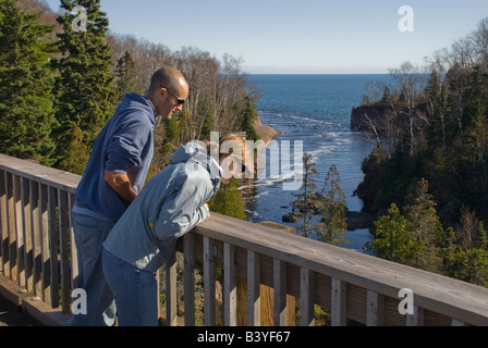 Usa, Minnesota. A Couple On A Bridge Overlooking The Baptism River In 