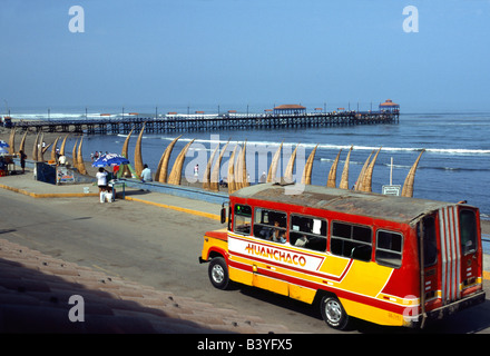 Peru, La Libertad, Huanchaco. Colourful local bus on the beachfront at the fishing village and beach resort of Huanchaco, near Trujillo in northern Peru. Huanchaco is famous for its traditional caballito (reed boat) fishermen. Stock Photo