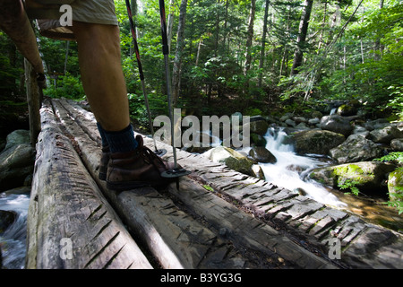 A hiker on a bridge over Gorge Brook in New Hampshire USA (MR) Stock Photo