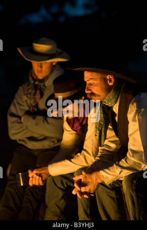 USA, Oregon, Seneca, Ponderosa Ranch. Three cowboys sitting around a campfire. (MR) (PR) Stock Photo