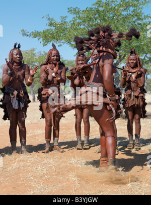 Namibia, Kaokoland. Himba women perform the otjiunda dance, stamping their feet, clapping and chanting in a circle. Their bodies Stock Photo