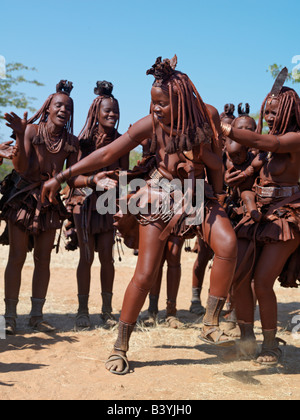 Namibia, Kaokoland. Himba women perform the otjiunda dance, stamping their feet, clapping and chanting in a circle. Their bodies Stock Photo