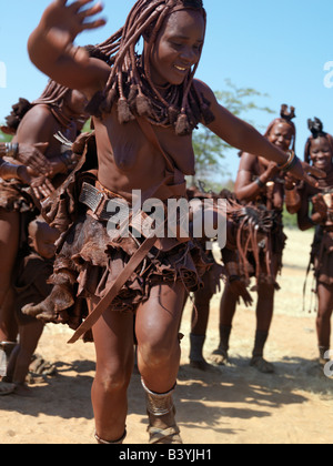 Namibia, Kaokoland. Himba women perform the otjiunda dance, stamping their feet, clapping and chanting in a circle. Their bodies Stock Photo