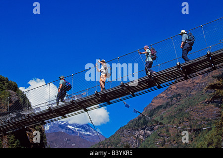 .Nepal, Solo-Khumbu, Jorsale Trekkers crossing a suspension bridge over the Dudh Kosi river, near Jorsale. Stock Photo