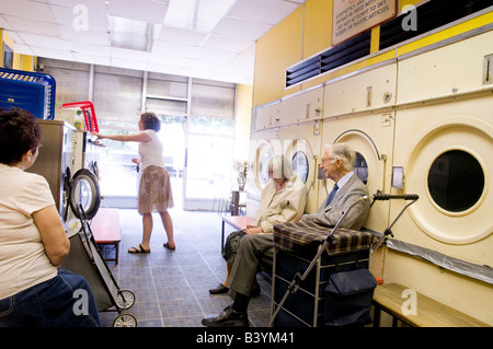 People waiting for their washing in a launderette London England UK Stock Photo