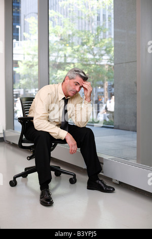 Portrait of businessman with hand to head in Chicago office building Stock Photo