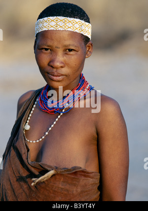 Namibia, Eastern Bushmanland, Tsumkwe. An attractive !Kung woman. The !Kung are San hunter-gatherers, often referred to as Bushmen. They differ in appearance from the rest of black Africa having yellowish skin and being lightly boned, lean and muscular. They speak with four distinct click consonants.The !Kung live in the harsh environment of a vast expanse of flat sand and bush scrub country straddling the Namibia-Botswana border. Until recently, their way of life had remained unchanged for thousands of years. Few now live solely by hunting and gathering. Stock Photo
