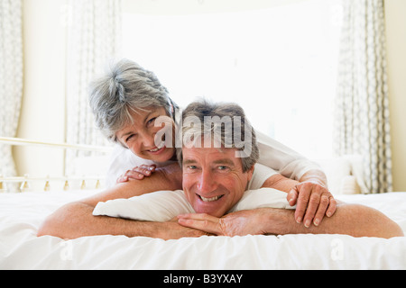 Couple lying on bed together smiling