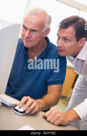 Two men at computer looking at monitor (high key) Stock Photo