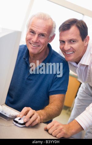 Two men at computer smiling (high key) Stock Photo