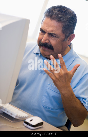 Man at computer looking at monitor frustrated (high key) Stock Photo