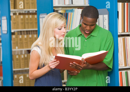 Man and woman in library reading book (depth of field) Stock Photo