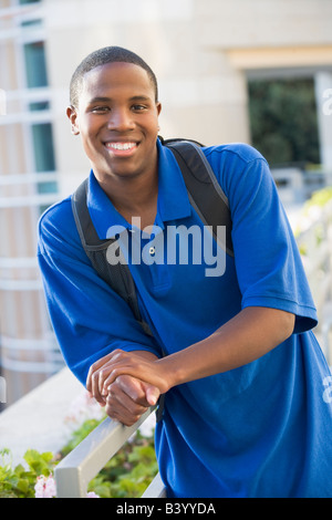 Man standing on balcony leaning on railing (selective focus) Stock Photo