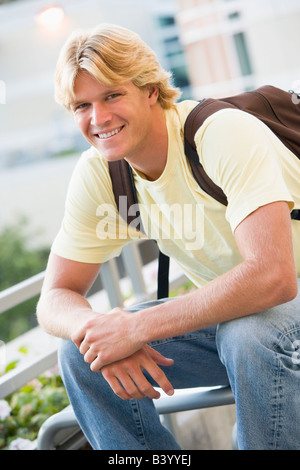 Man sitting outdoors on bench smiling (selective focus) Stock Photo