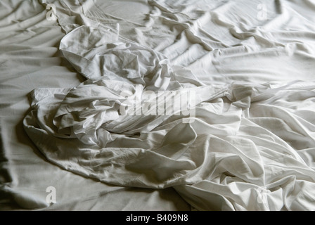 White bed sheets slept in, frowzled, disheveled an unmade bed. HOMER SYKES Stock Photo