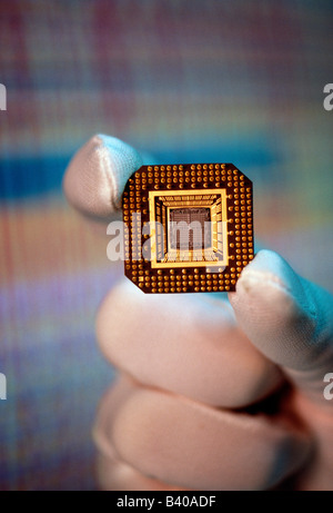 Technician in clean room environment holds micro computer chip Stock Photo