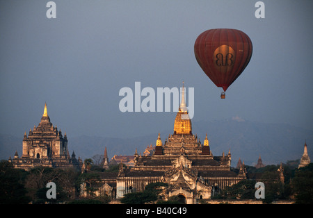 Hot air balloon at sunrise passing behind Ananda temple (right) in Bagan, Myanmar Stock Photo