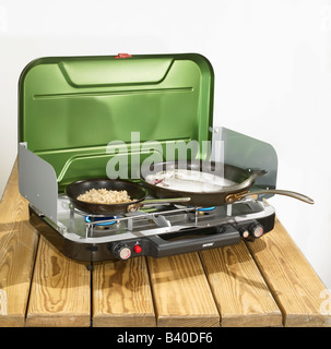 A camp stove with fish cooking on it Stock Photo