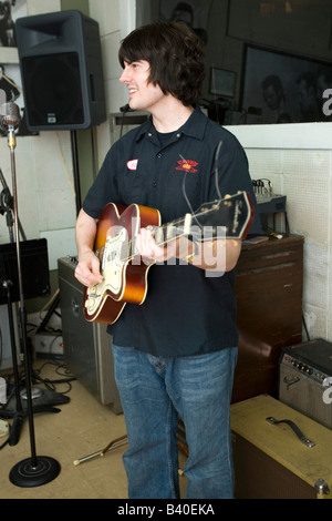 Young man demonstrates semi acoustic guitar technique at Sun Studio Memphis Tennessee USA. Stock Photo